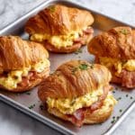 Croissant Breakfast Sandwiches with Dijon Honey Spread, Ham, Bacon, and Scrambled Eggs Recipe