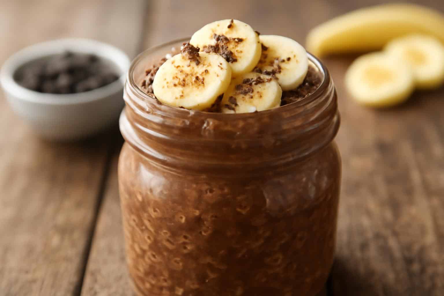 Creamy dark chocolate banana overnight oats topped with banana slices and chocolate shavings