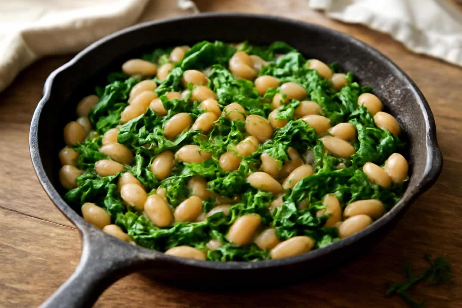 White bean skillet with spinach garnished with fresh herbs and lemon zest