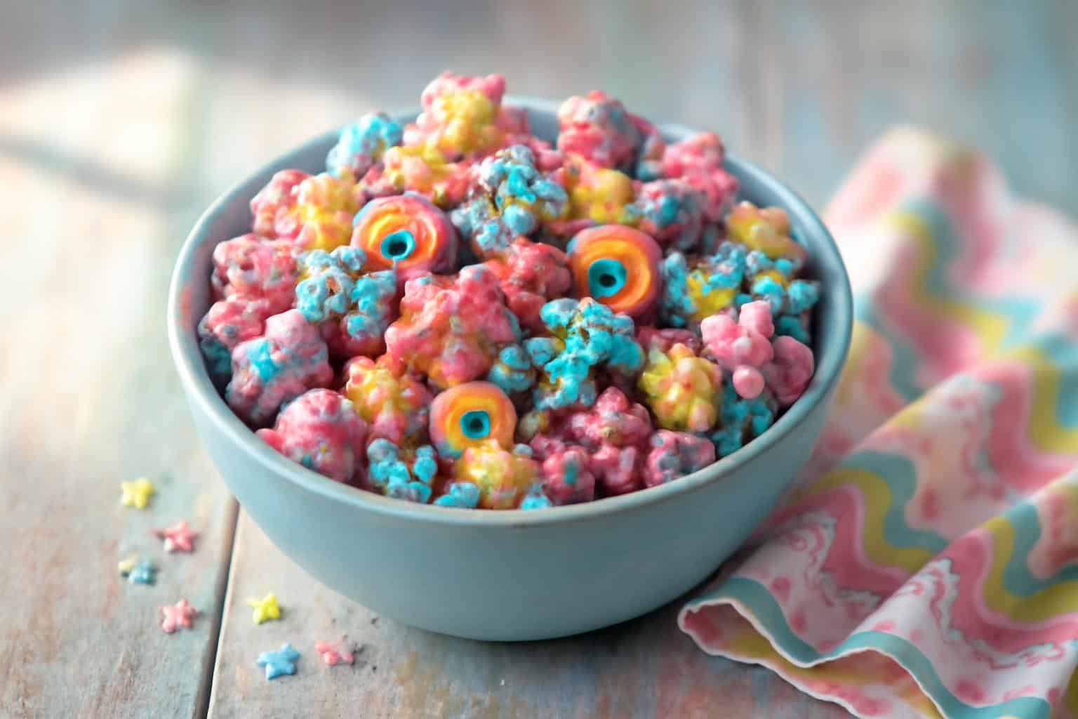Bowl of chewy colorful unicorn marshmallow popcorn with rainbow marshmallow bits and edible glitter