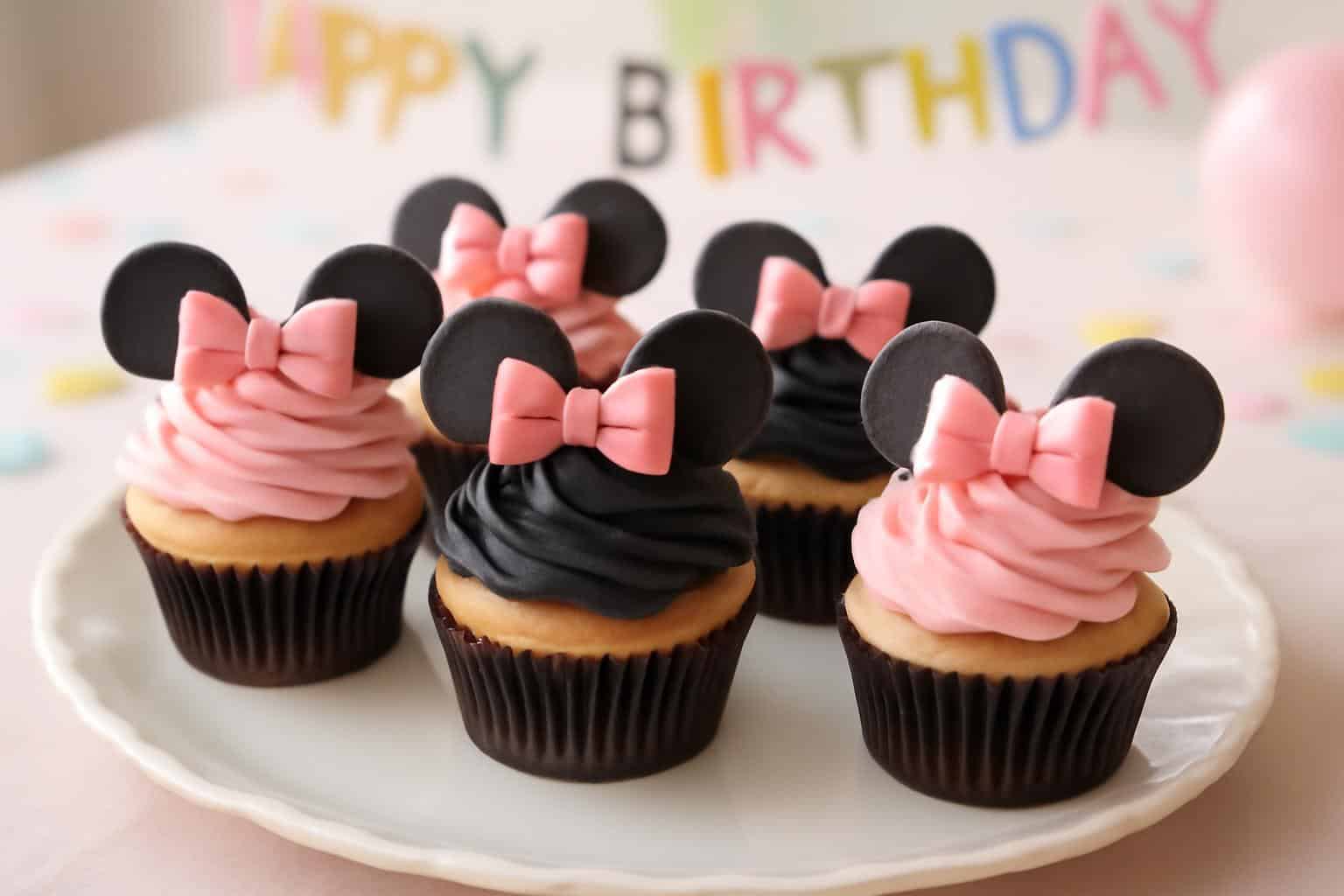 Minnie mouse birthday cupcakes with pink and black frosting and edible ears decoration